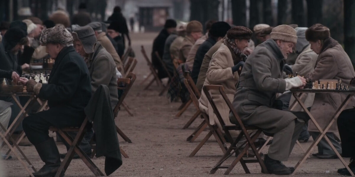 Русские дедушки играют в шахматы в парке.