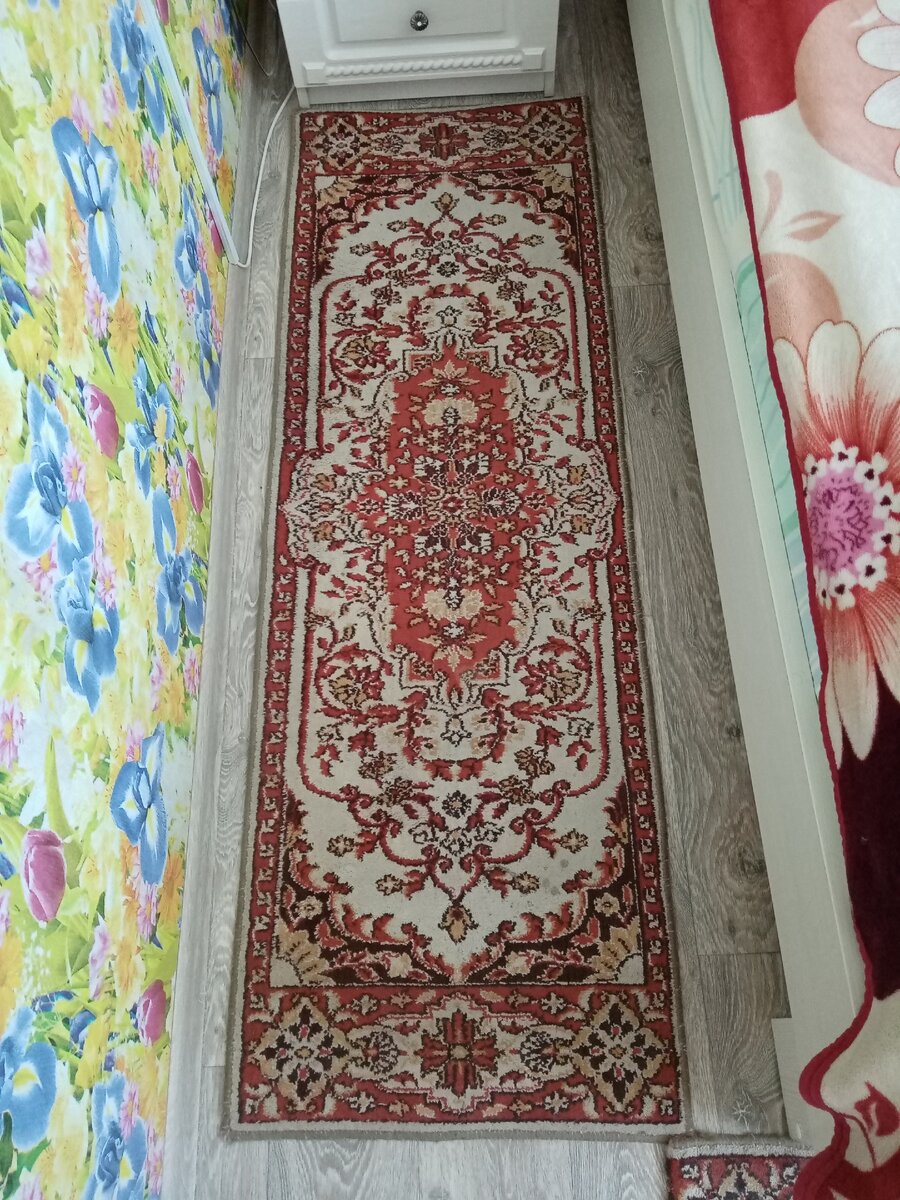дорожка, раньше застилала кресло, сейчас лежит на полу в спальне вдоль кровати