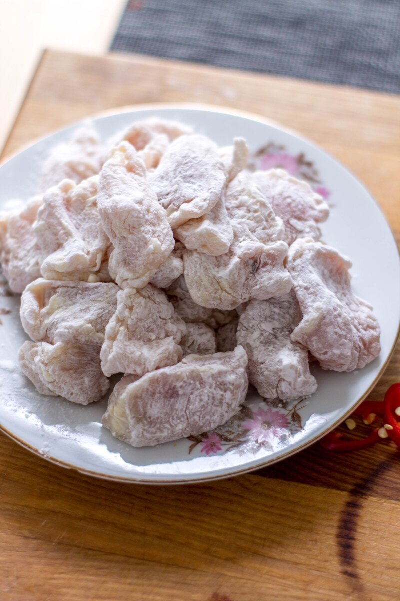 Обваливаем кусочки курицы в крахмале