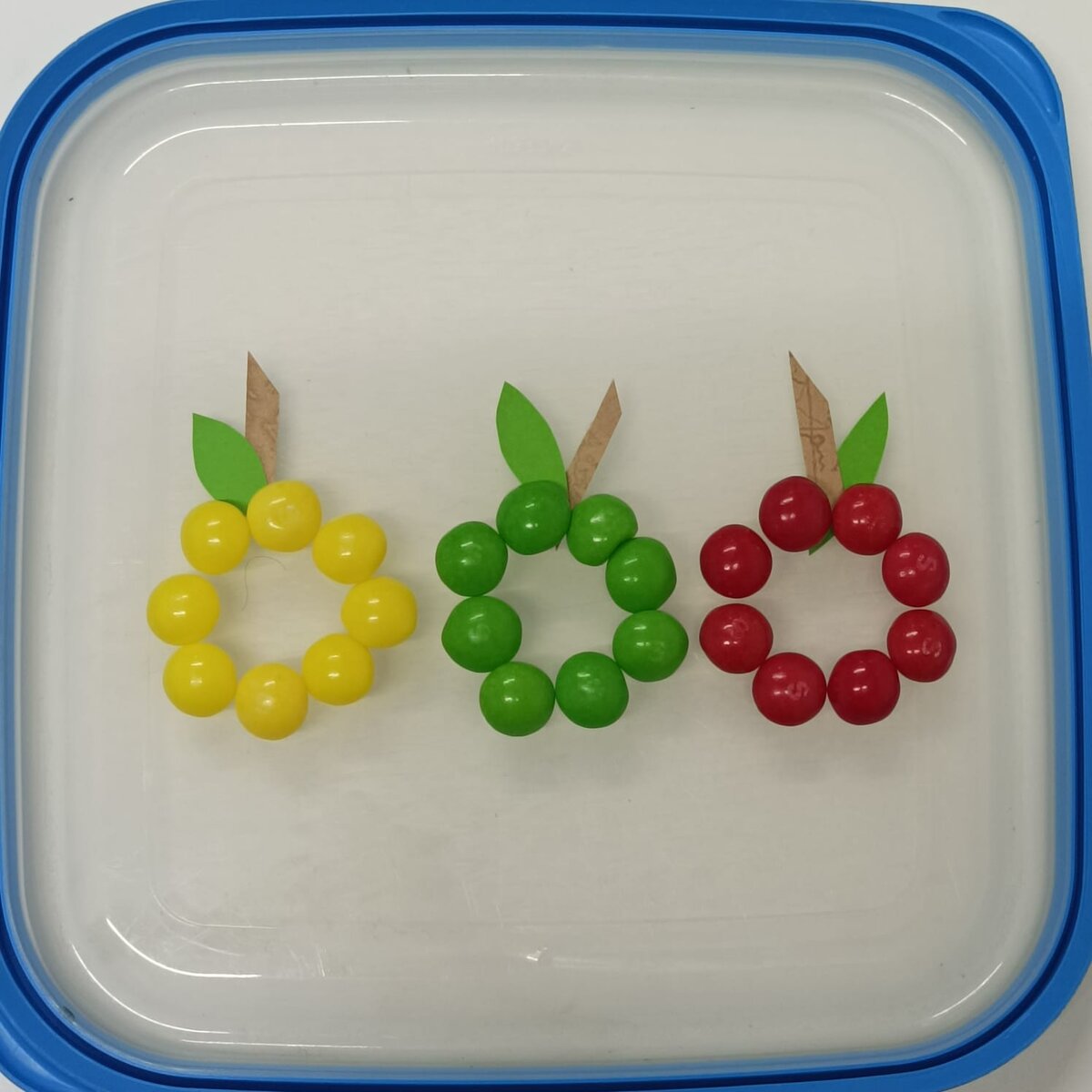 Выложите драже в виде яблочек