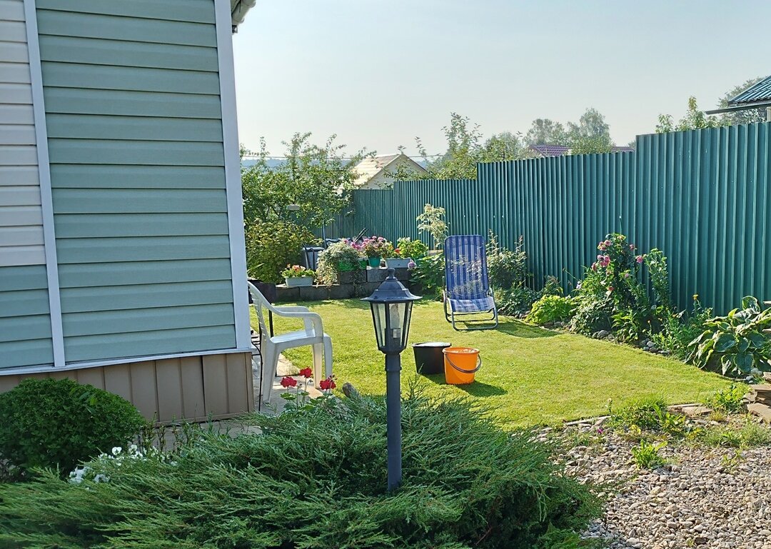 Вид на газон от калитки в солнечный день.