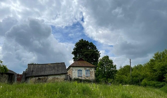 ЭТО САМЫЙ ПЕРВЫЙ ДОМ В ДЕРЕВНЕ НА ВЪЕЗДЕ. ОКОЛО НЕГО Я ОСТАВЛЯЮ СВОЙ АВТОМОБИЛЬ И ДАЛЬШЕ ИДУ ПЕШКОМ. ЭТОТ ДОМ НЕ ЗАБРОШЕННЫЙ. В НЕМ НИКТО НЕ ЖИВЕТ, НО ЛЕТОМ ПЕРИОДИЧЕСКИ ПРИЕЗЖАЮТ ДЕТИ БЫВШИХ ХОЗЯЕВ. ТРАВА ВОКРУГ ДОМА ПОКОШЕНА. ДОМ ЕЩЕ БОДРЕНЬКИЙ