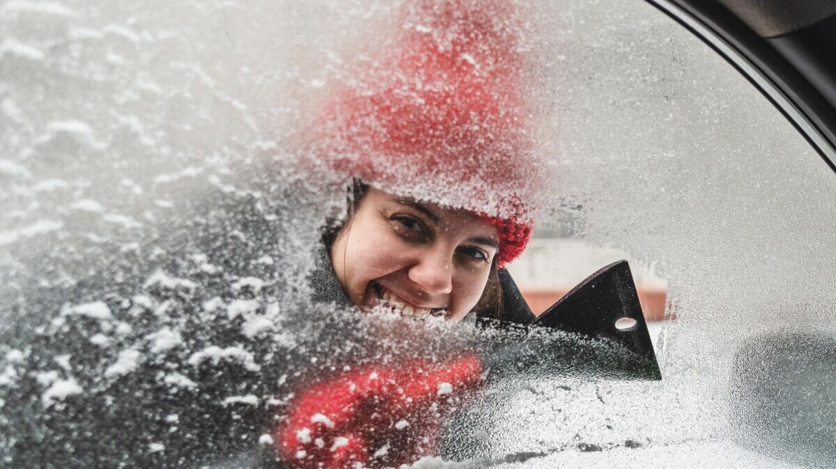    Девушка чистит стекло в автомобиле © iStock.com / Vera_Petrunina