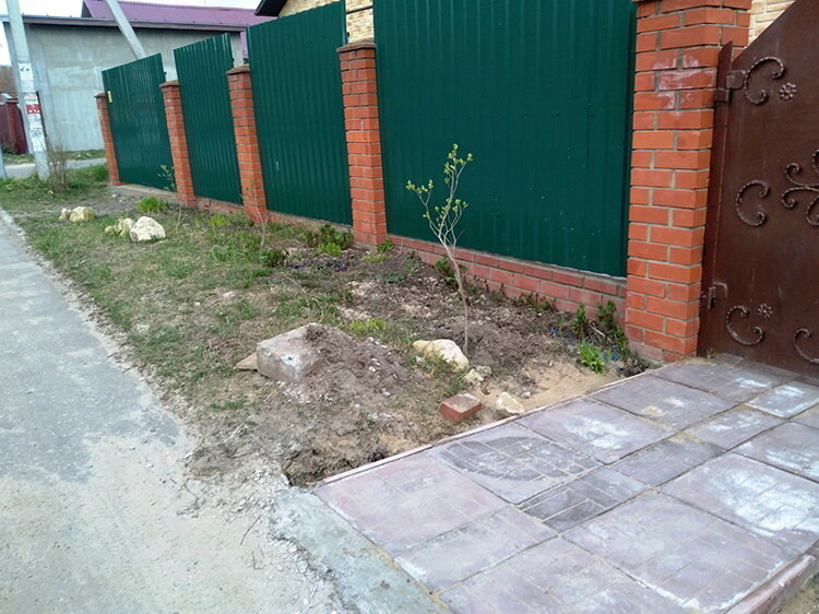 Участок у забора вместе с благоустроенным входом. Пока лежит плита после ремонтных работ