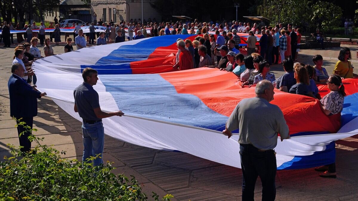    Жители станицы Луганской с флагом России© РИА Новости / Максим Захаров