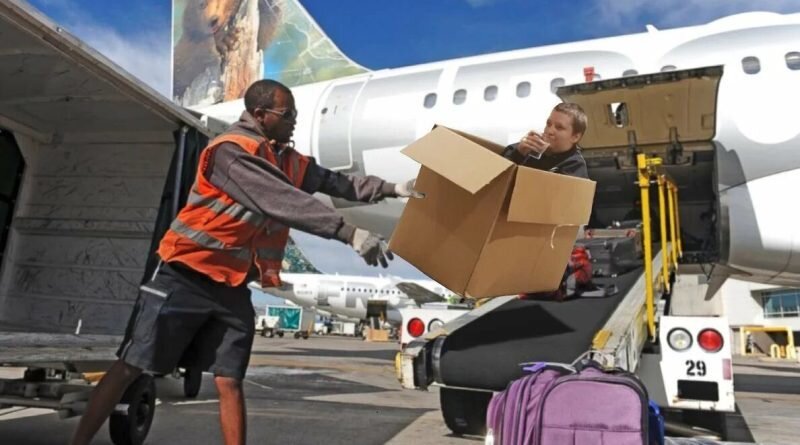 Чёрный грузчик бросает коробку в аэропорту