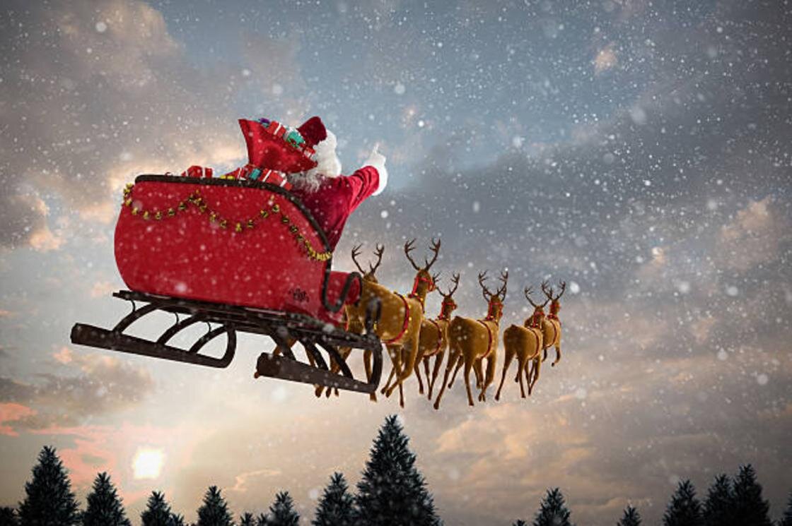    Санта-Клаус летит в санях по небу:iStockPhoto