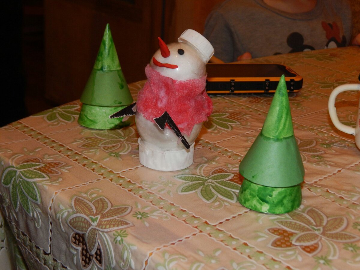 Рабочий снеговик, с пилой и топором на фоне елок