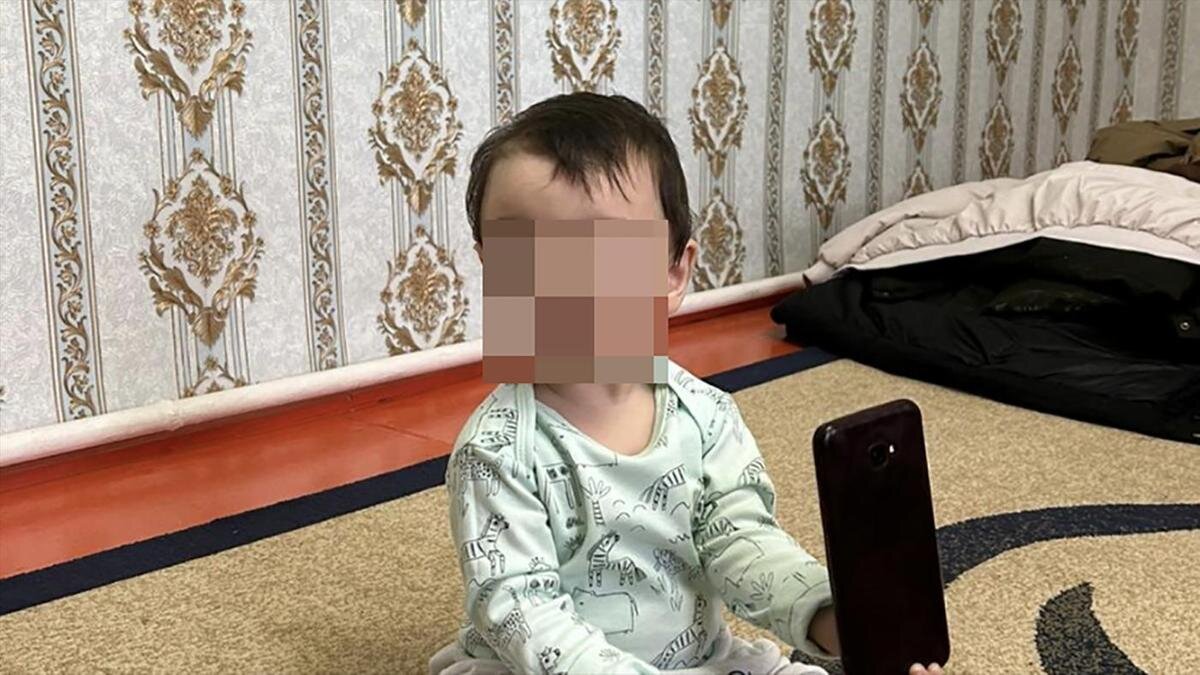    Мальчик сидит на ковре с телефоном:из личного архива