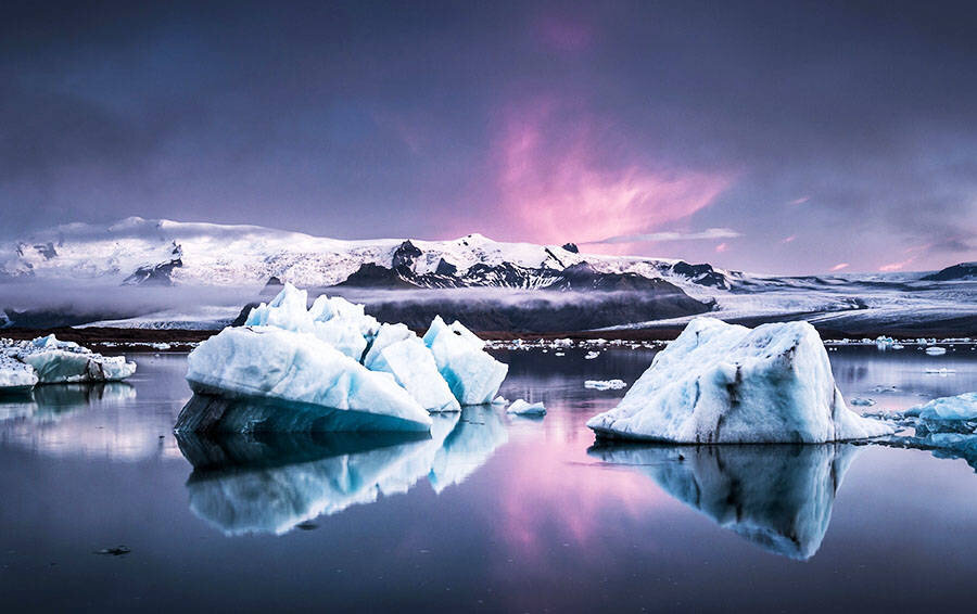 Лагуна #Йекюльсаурлоун очень популярна среди #фотографов. Здесь везде #царство льда, ледяные глыбы бирюзового цвета, которые течением приносит к берегу, красиво контрастируют с темным песком пляжа. #Лагуна соединяется с океаном узким, довольно мелким проливом, над которым переброшен автомобильный мост. Через этот пролив, #течение выносит #айсберги из лагуны в открытый #океан. Иногда айсбергов бывает так много, что они закупоривают узкое горло пролива, но, через некоторое время движение айсбергов из лагуны к океану возобновляется. Одной из интересных достопримечательностей лагуны считается и черный #пляж, с большими колониями птиц. Воды океана выталкивают большие полупрозрачные льдины на черный песок, и играют своими гранями на #солнце как огромные #бриллианты.