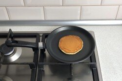 ПОШАГОВОЕ ПРИГОТОВЛЕНИЕ

ШАГ 1:
Как сделать панкейки на кефире? Подготовьте продукты. Кефир лучше взять пожирнее, он более густой. Для более жидкого кефира потребуется больше муки, и панкейки могут стать "резиновыми". Чем кислее будет кефир, тем пышнее получатся панкейки, так как реакция между содой и кислотой будет сильнее. Поэтому отлично подойдет старый, уже прокисший кефир. Вместо кефира можете взять натуральный йогурт без добавок.
ШАГ 2:
Кефир налейте в ковш и слегка подогрейте. Делайте это на небольшом огне, при постоянном помешивании, чтобы он не свернулся. Всыпьте в кефир соду и перемешайте венчиком. За счет того, что кефир теплый и кислый, начнется бурная реакция между содой и кислотой. Масса сразу запузырится и увеличится в объеме. именно благодаря этому панкейки приобретут свою пышность.
ШАГ 3:
Яйца разбейте в другую миску. Добавьте к ним сахар и соль. Слегка взбейте яйца венчиком или вилкой. Не надо их взбивать до пены, просто размешайте. Пышность в этом рецепте достигается не за счет взбитых яиц.
ШАГ 4:
Муку просейте в большую миску. Просеивание обогащает муку воздухом, что делает выпечку более пышной.
ШАГ 5:
Влейте яичную смесь к кефирной. Аккуратно перемешайте.
ШАГ 6:
Влейте жидкие ингредиенты в муку тонкой струйкой, при постоянном размешивании венчиком. Если сделать наоборот, всыпать муку в кефир, то в тесте образуются комочки. В противном случае комочков удастся избежать. Размешайте тесто до однородного состояния. Не переусердствуйте с размешиванием, как только вся мука равномерно распределится, остановитесь. Пусть в тесте останется как можно больше воздуха.
ШАГ 7:
Растопите в сотейнике сливочное масло. Делайте это на небольшом огне. Следите, чтобы масло не начало кипеть, от него может отделиться сыворотка. Можете не ждать когда растопится весь кусок, а снимать с огня. От тепла остатки масла все равно растают.
ШАГ 8:
Растопленное масло остудите, а затем влейте в тесто. Хорошо размешайте тесто венчиком, чтобы все масло перемешалось. Сливочное масло придаст панкейкам очень приятный слегка ореховый аромат. Тесто буде по консистенции как густая сметана.
ШАГ 9:
На среднем огне разогрейте сковороду. Лучше всего взять специальную блинную с антипригарным покрытием. Если такой нет, то возьмите чугунную или любую, к которой не прилипают блины. Это важно, потому что жарить панкейки надо без масла. Если вы не уверены в своей сковороде, то перед первым блином смажьте ее тонким слоем растительного масла. Выкладывайте тесто на сковороду ложкой, формируя ровный блин среднего размера.
ШАГ 10:
Жарьте панкейк на среднем огне до появления пузырей на поверхности.
ШАГ 11:
Переверните блин на другую сторону. Жарьте его до готовности с другой стороны. Таким образом пожарьте все панкейки. Традиционно их делают размером с блюдце. Готовые панкейки складывают один на другой, а сверху кладут масло. Едят панкейки, отрезая сразу всю стопку, наподобие куска торта.