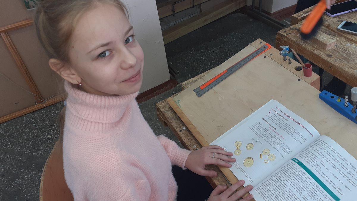 Варвара изучает чертежи в учебнике
