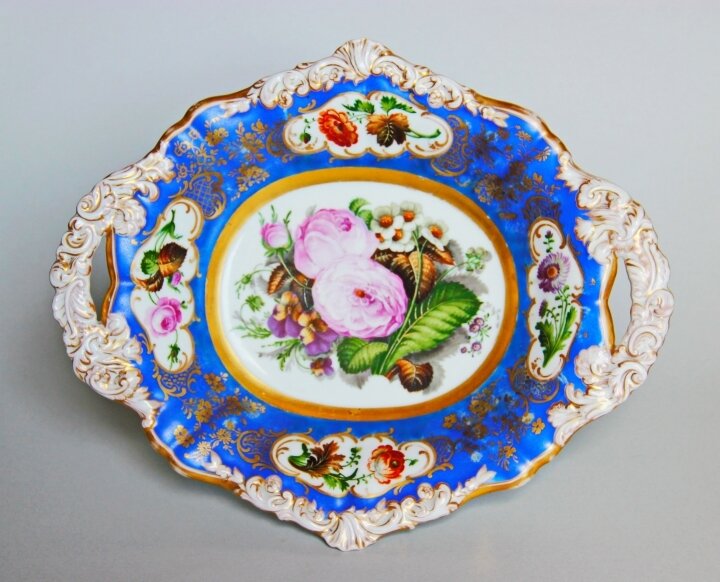 В галерее в основном представлены блюда и тарелки фирмы А. Попова с цветочным декором (но не только!). На данном фото изображено блюдо сложной формы с хватами, барочным рельефом (видимо, это выпуск уже конца 1840-х и позднее), с ярко-голубым крытьём без градиента с богатой позолотой и с цветочным узором в "окнах". Экспонат, безусловно, музейной ценности. Фото взято из свободного доступа в интернете.