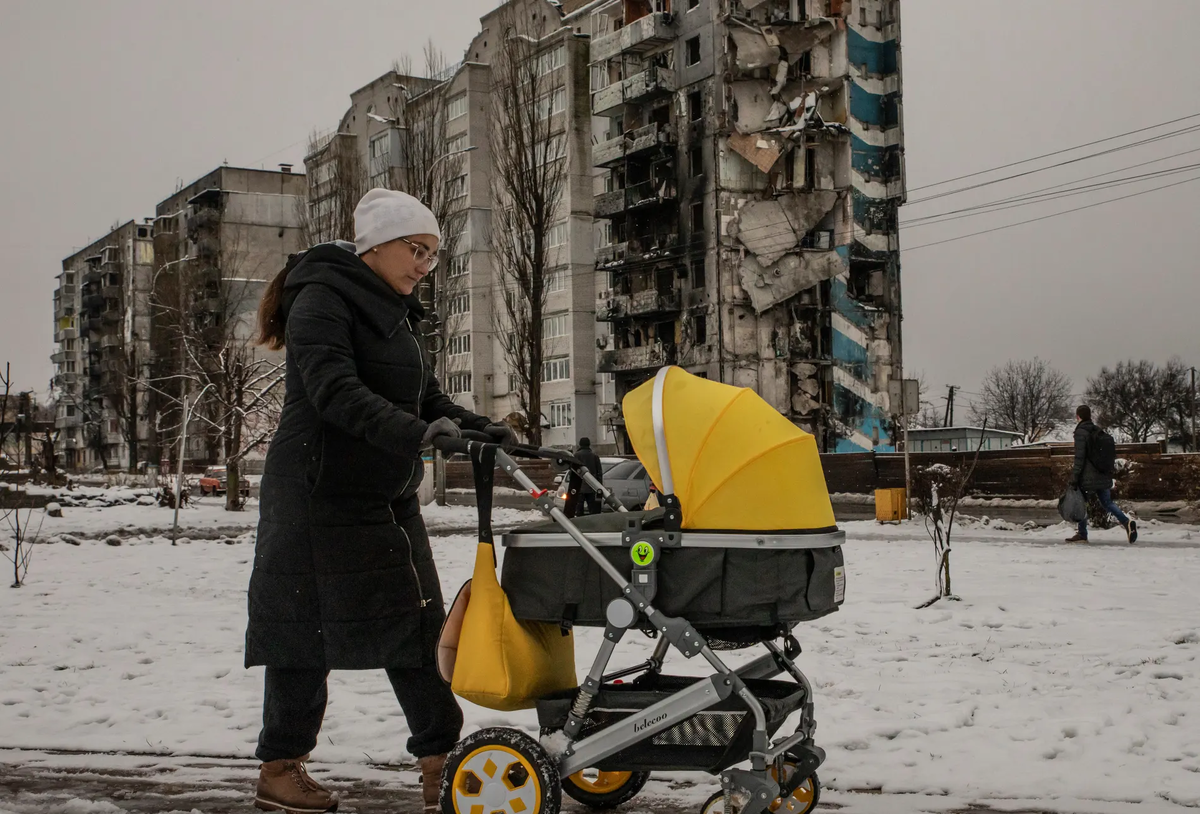 Женщина катит коляску по улицам Бородянки к северу от Киева.