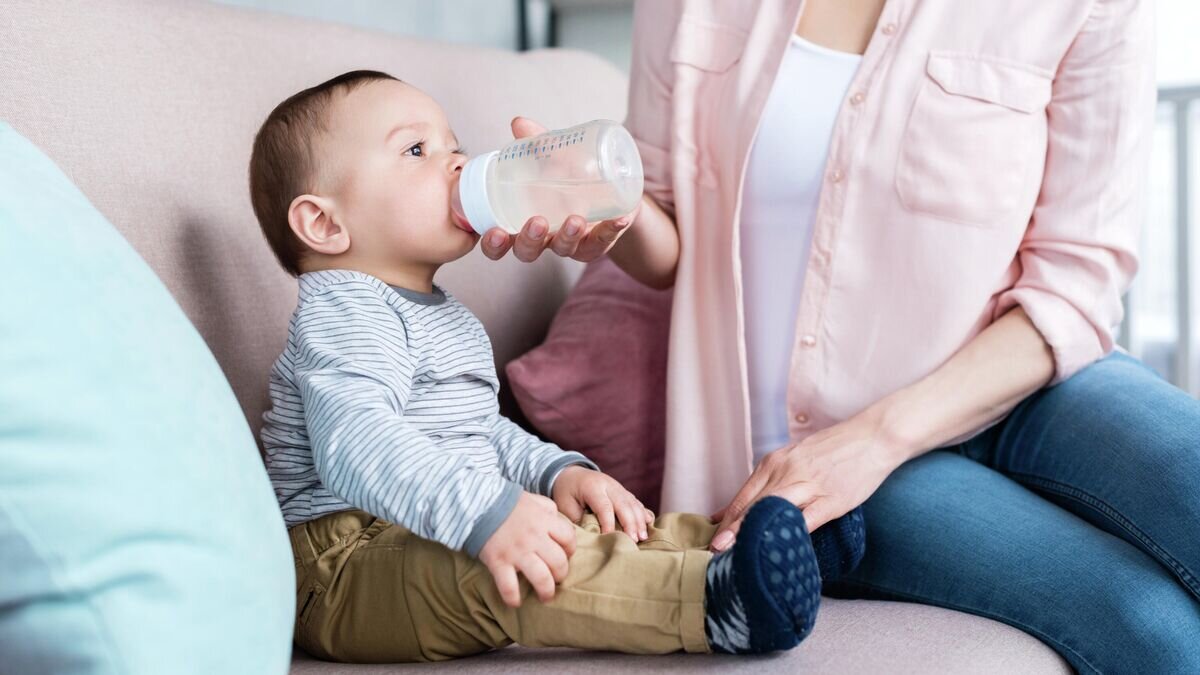    Младенец пьет воду из бутылочки© Depositphotos / AllaSerebrina