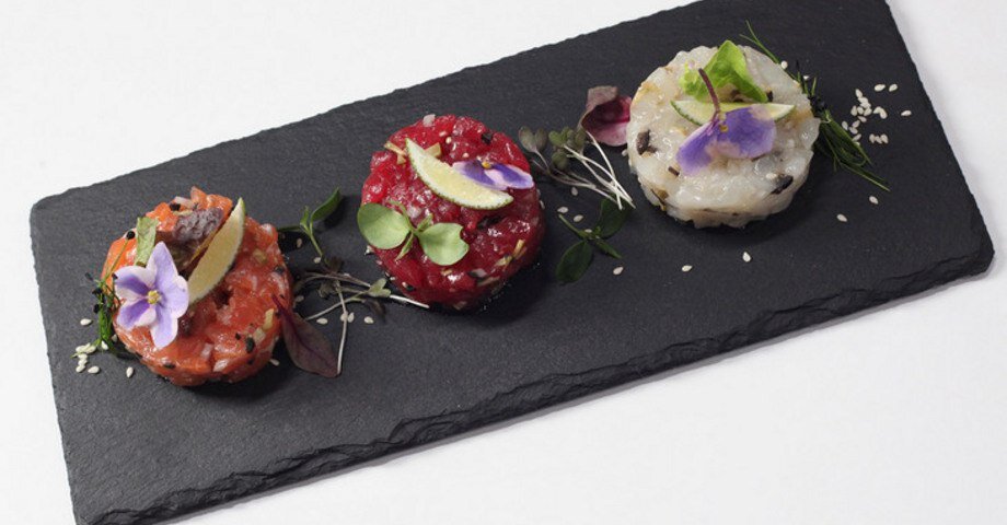 Ингредиенты:  • тунец 150 граммов 
• гребешки 150 граммов 
• лосось 150 граммов 
• лук-шалот 
• оливки 20 граммов 
• маслины 
• каперсы 10 граммов 
• масло оливковое 
• черный перец 
• кресс-салат 
• соль 
• лайм 1 штука 
• кунжут 
• мангольд 
• салат латук 
• салат оклиф 10 граммов 
• цветы 