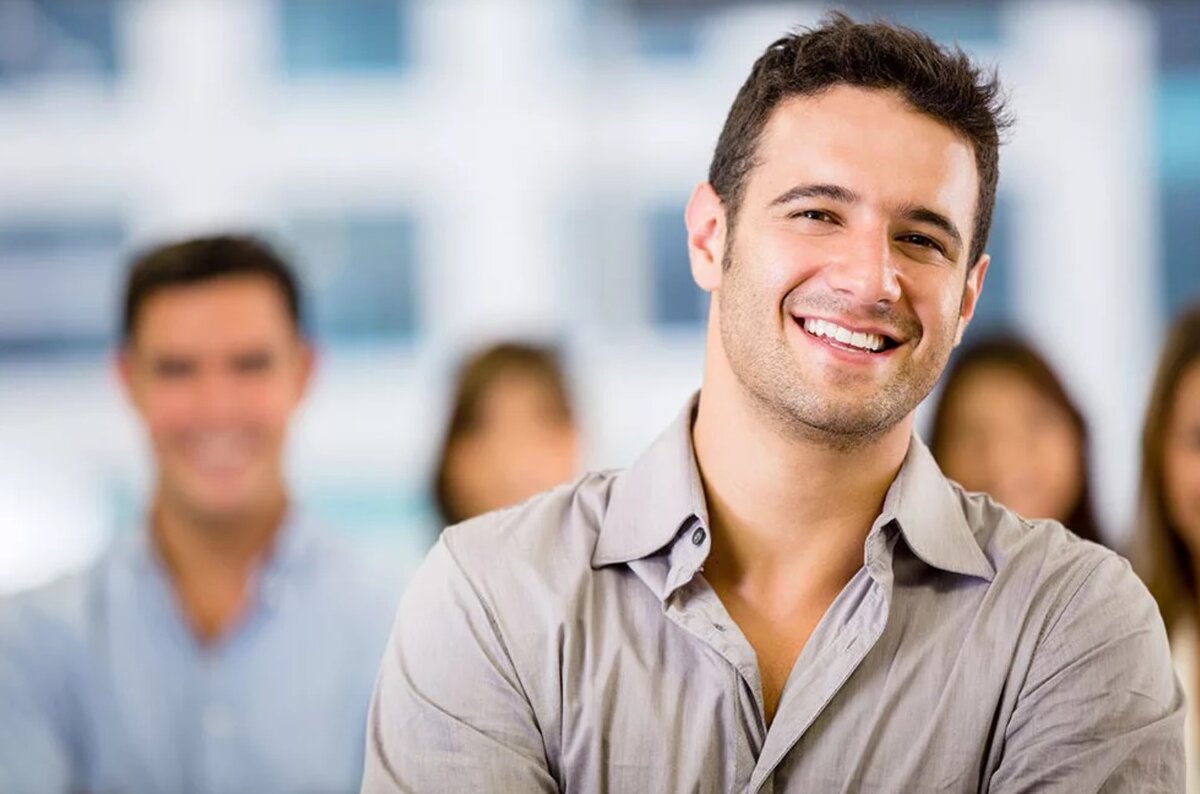 Здоровый мужчина. Позитивный парень. Молодой бизнесмен. Улыбчивый человек. Мужчина радуется.