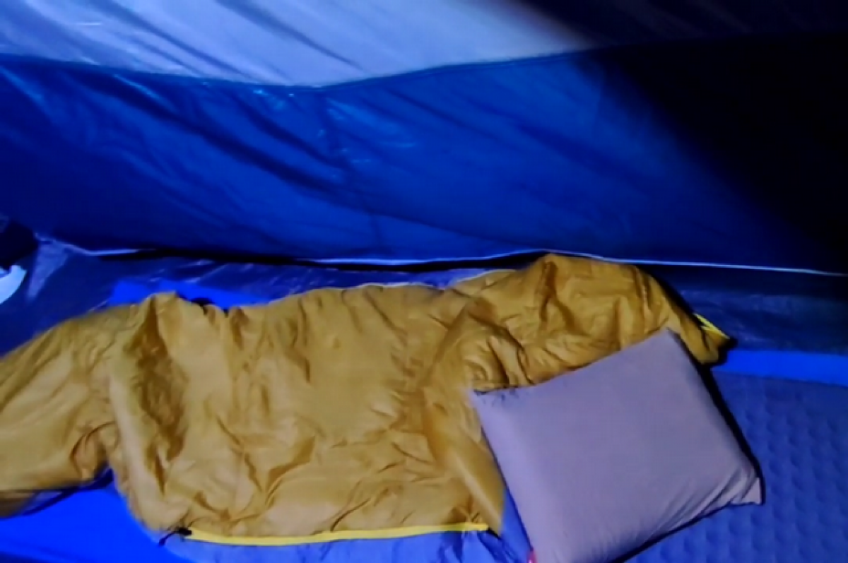    Программист ночует в спальном мешке и просторной палатке.