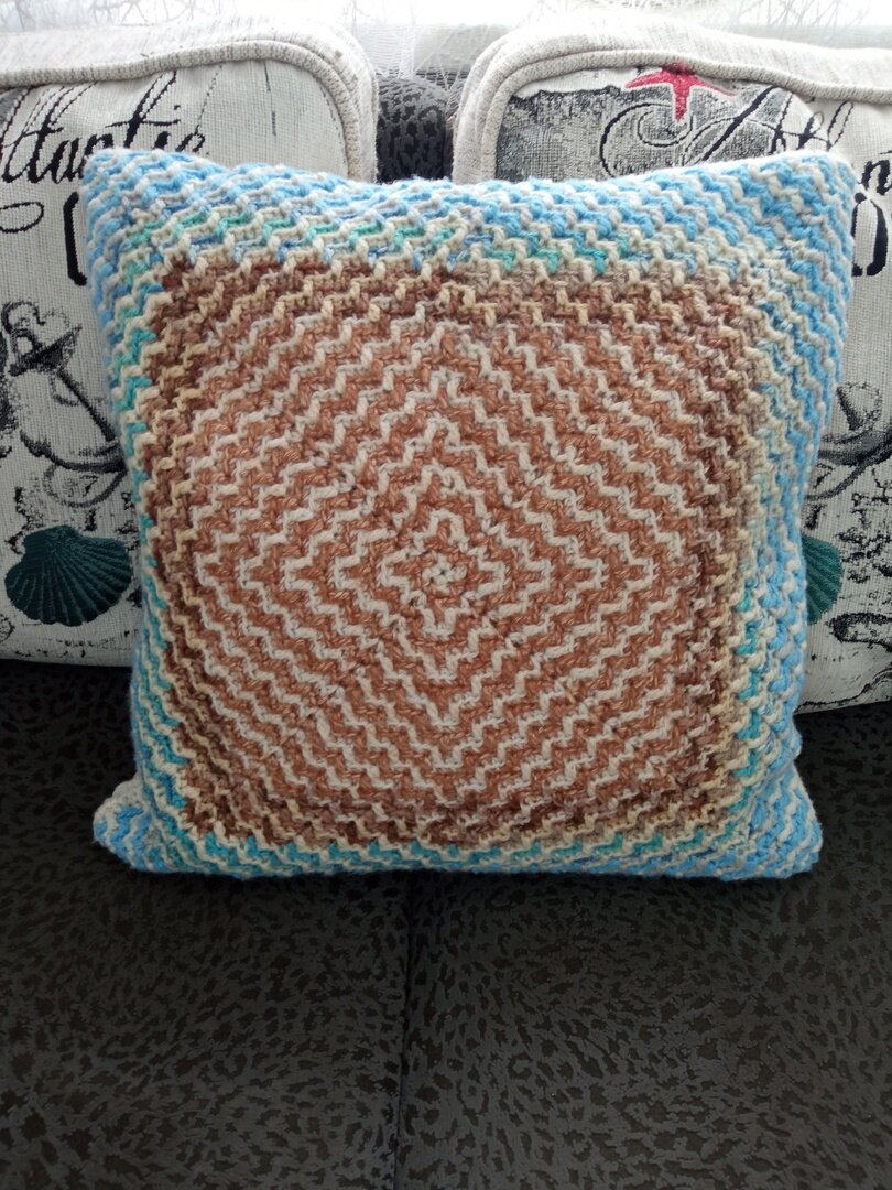 подушка связана из остатков: несколько коричневых нитуй, белая, бежевая, да и голубых три разных нити. 