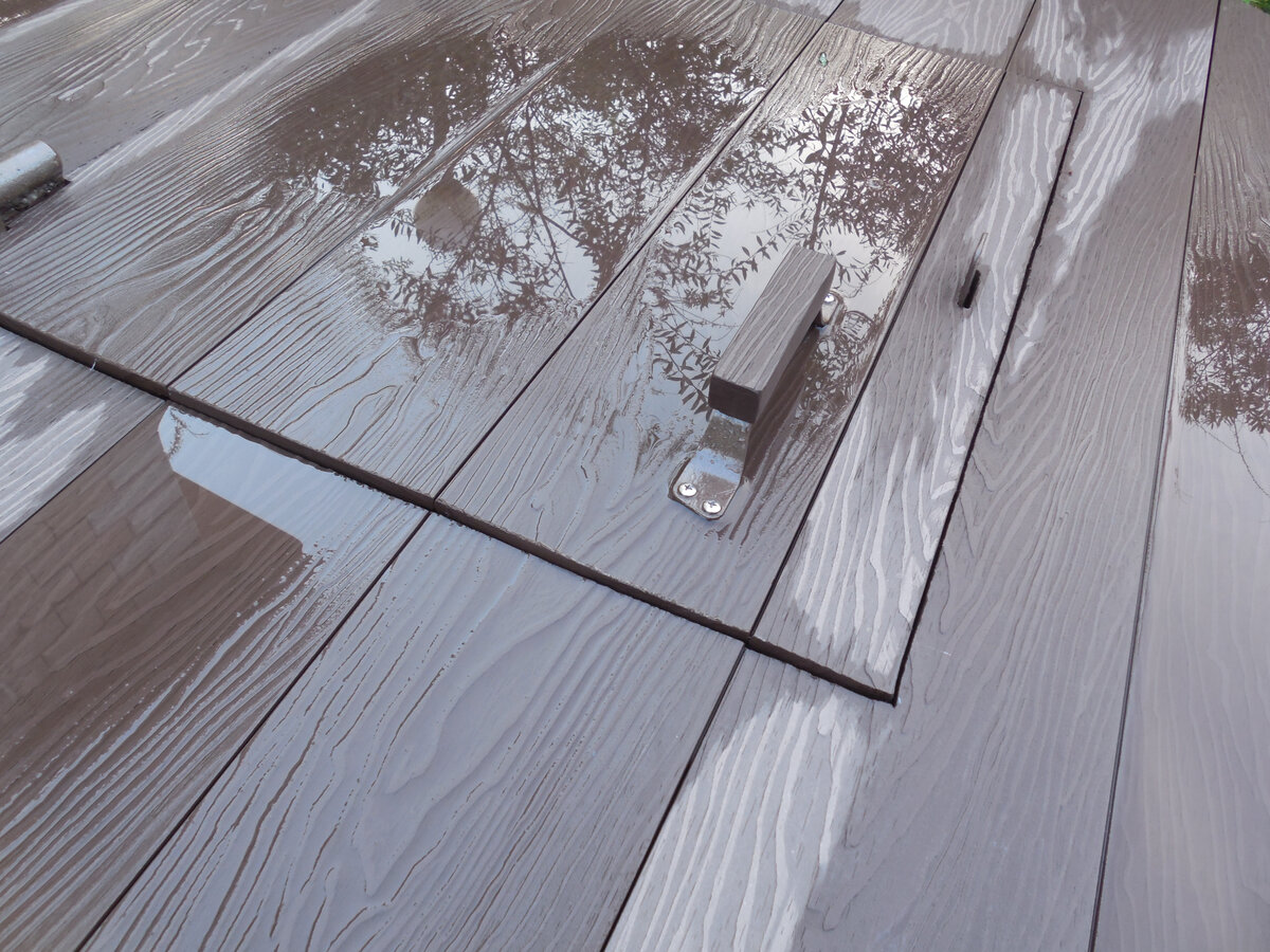 Наш колодец после обшивки ДПК. После очередного ливня