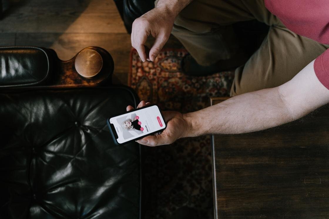    Телефон с открытым приложением Tinder в мужских руках:Pexels