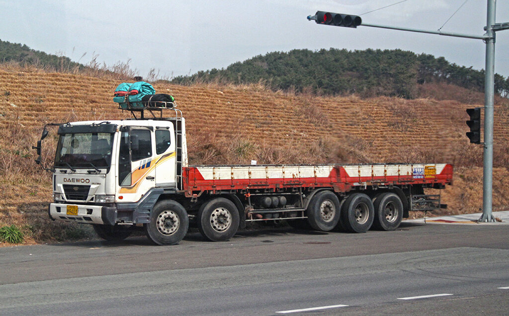 «Старичок» Daewoo Ultra 10х4 с наиболее распространенным вариантом компоновки осей: первая ось в тройной задней тележке выполнена подъемной и имеет односкатные поворотные колеса 