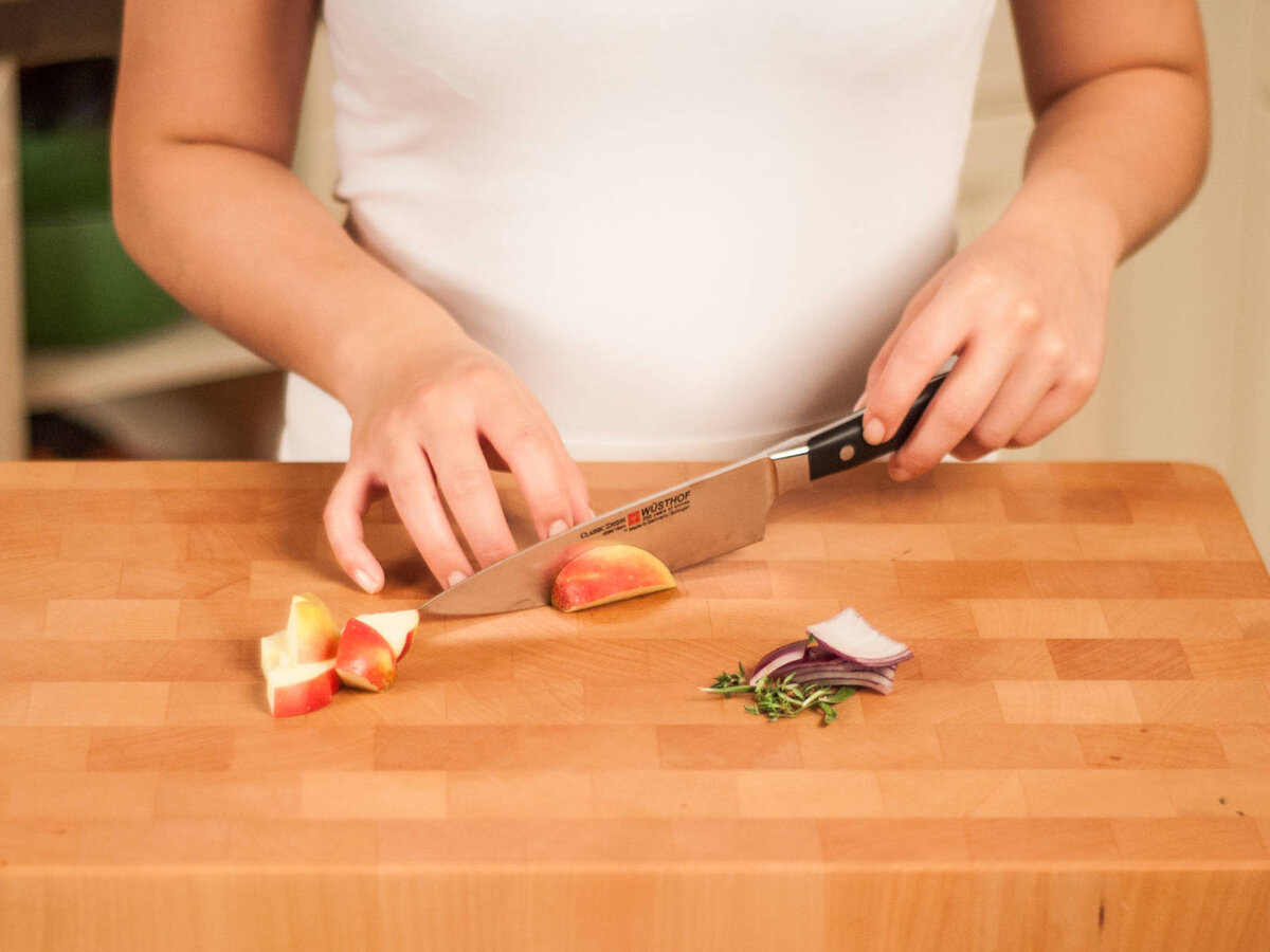 1. Разогрейте духовку до температуры 160°C. Для начинки, возьмите листья зелени и крупно порубите. Нарежьте лук кольцами, а яблоки нарежьте кубиками.