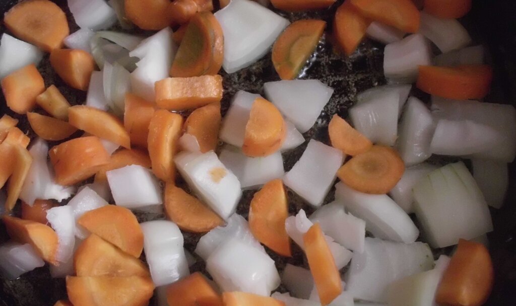 Лук и морковь на сковороде в процессе поджаривания, для приготовления летнего овощного рагу. Личное фото автора канала Житейская проза