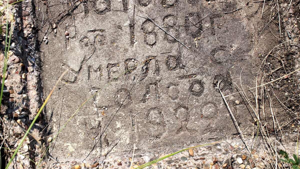 На разрушенном бульдозером кладбище осталась плита с надписью.