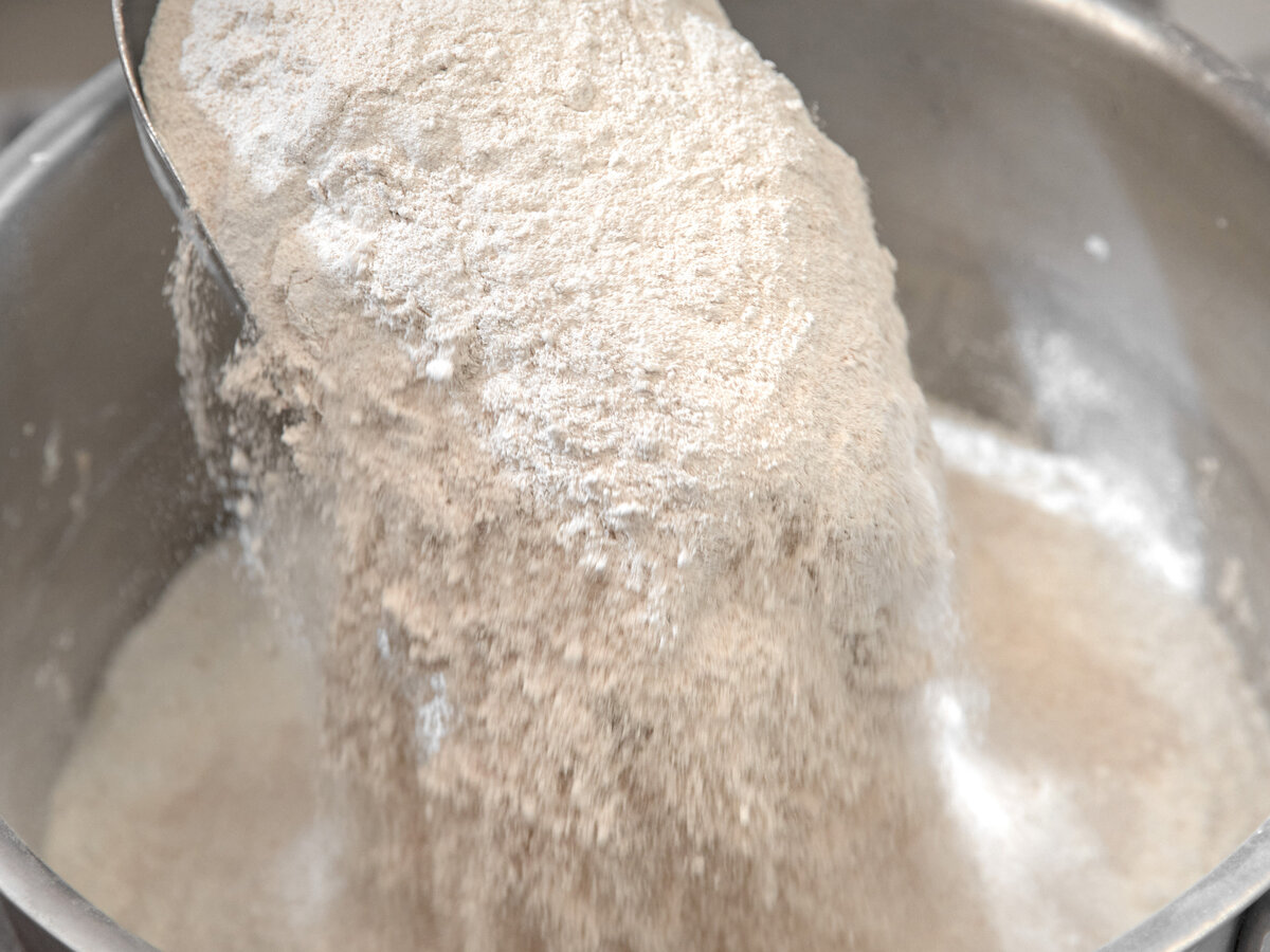 Потом к закваске и воде добавляется мука.