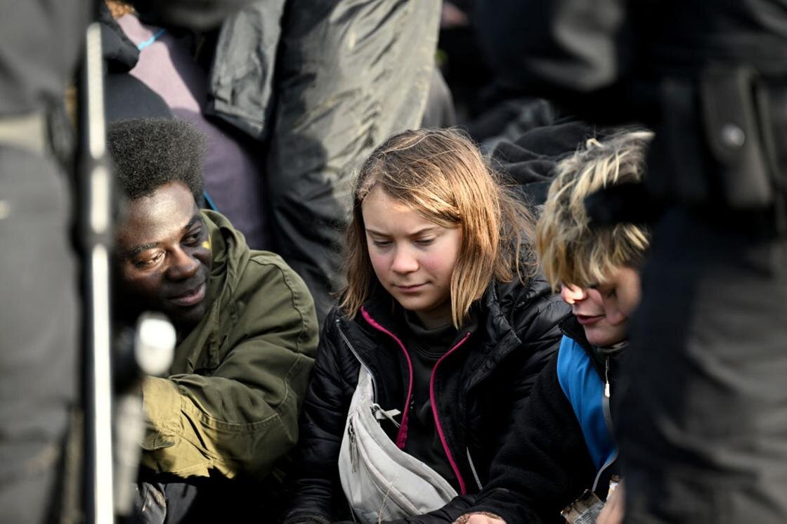    Грета Тунберг сидит в окружении других протестующих:Federico Gambarini / picture alliance / Getty Images