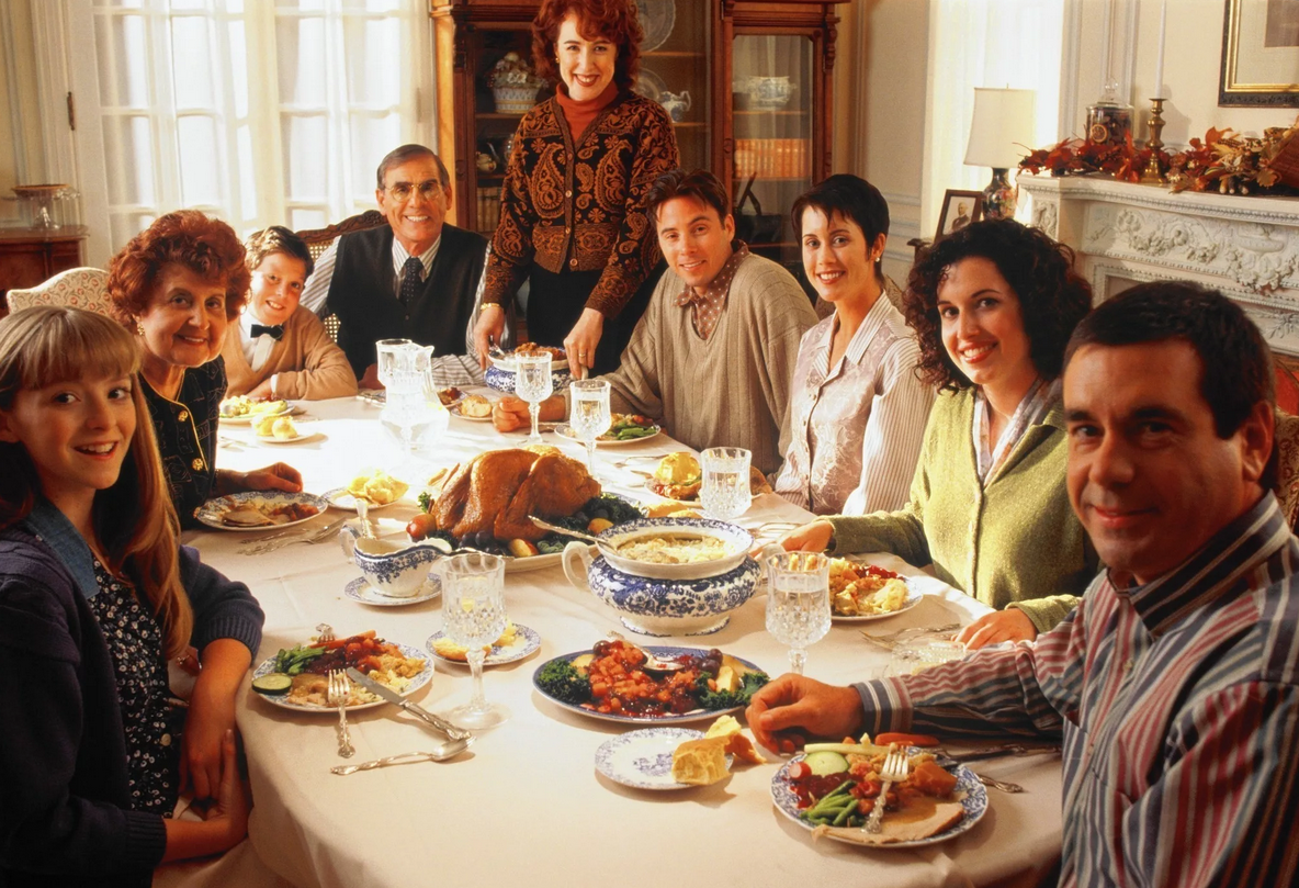 Обсуждают родственники. Семья за праздничным столом. Семейное застолье. Родственники за столом. Большая семья за праздничным столом.
