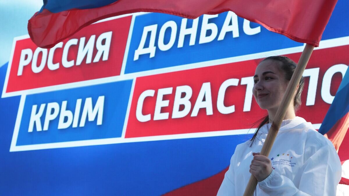    Девушка держит в руках флаг на праздничном митинге в честь восьмилетия провозглашения ДНР и ЛНР© РИА Новости / Макс Ветров