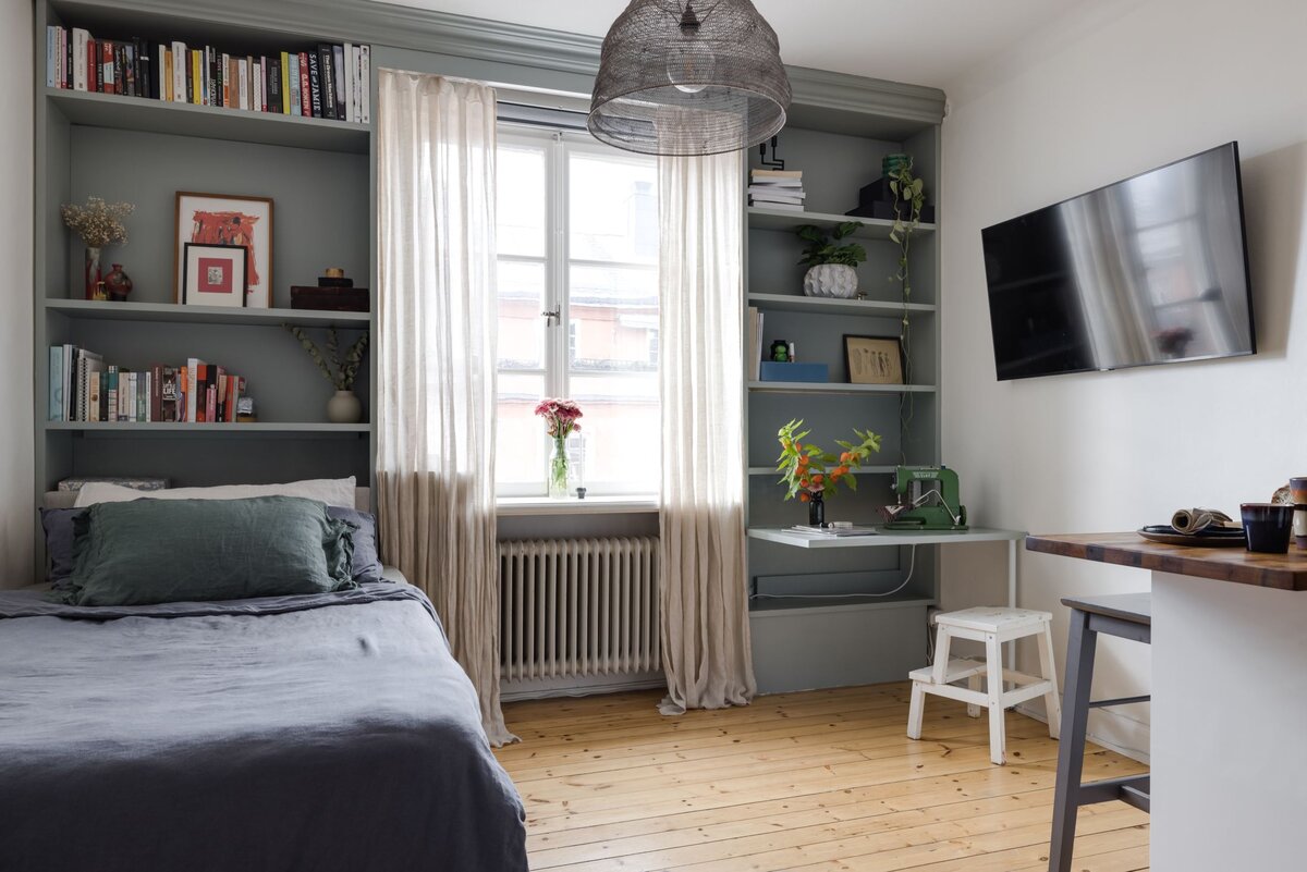 Мне понравилось, что каждый сантиметр пространства здесь играет свою роль. Стеллаж в стене, кровать и складной рабочий столик — всему нашлось свое место