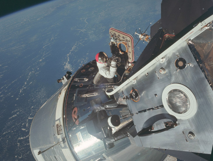 Пилот командного модуля Дэвид Скотт немного высунулся из люка корабля «Аполлон-9», чтобы сфотографировать прикрепленный к нему лунный модуль. Из открытых источников.