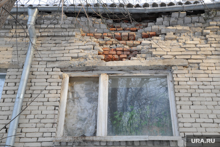    Кирпичный фасад дома начал обсыпаться из-за мокрого пятна