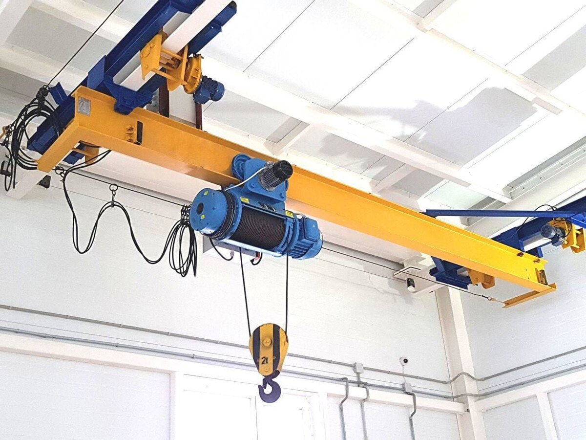 Ручные кран-балки
Довольно простая конструкция, которую в движение приводят рабочие руки. При этом таль может быть электрической, ручной или электромеханической. Непосредственно балку передвигают буквально руками. Подобные системы пользуются спросом в местах, где нет электрических сетей или происходят частые отключения. Интересный факт. Небольшие ручные кран-балки встречаются на СТО, сборочных цехах и фабриках, где нет необходимости закупать более сложное и дорогое оборудование. Ручные краны намного проще в обслуживании.