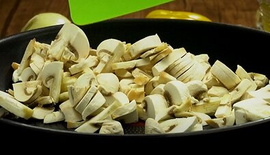 Разогрейте на плите антипригарную сковороду, высыпьте измельченные шампиньоны и слегка припустите на среднем огне.
