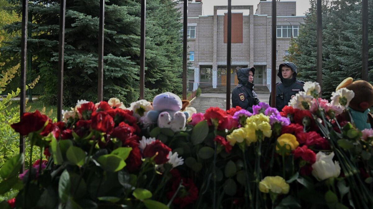    Сотрудники полиции у стихийного мемориала у школы №88 в Ижевске© РИА Новости / Илья Питалев