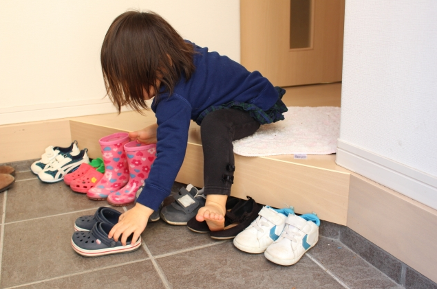 Вот тут хорошо видно, как девочка расставляет обувь носками к выходу, чтобы было удобно обувать.