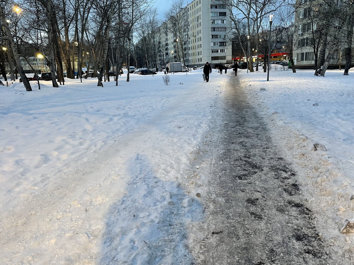 Неубранная пешеходная дорожка с ледяным налётом и параллельно ей слева - менее травмоопасная самостийная тропинка