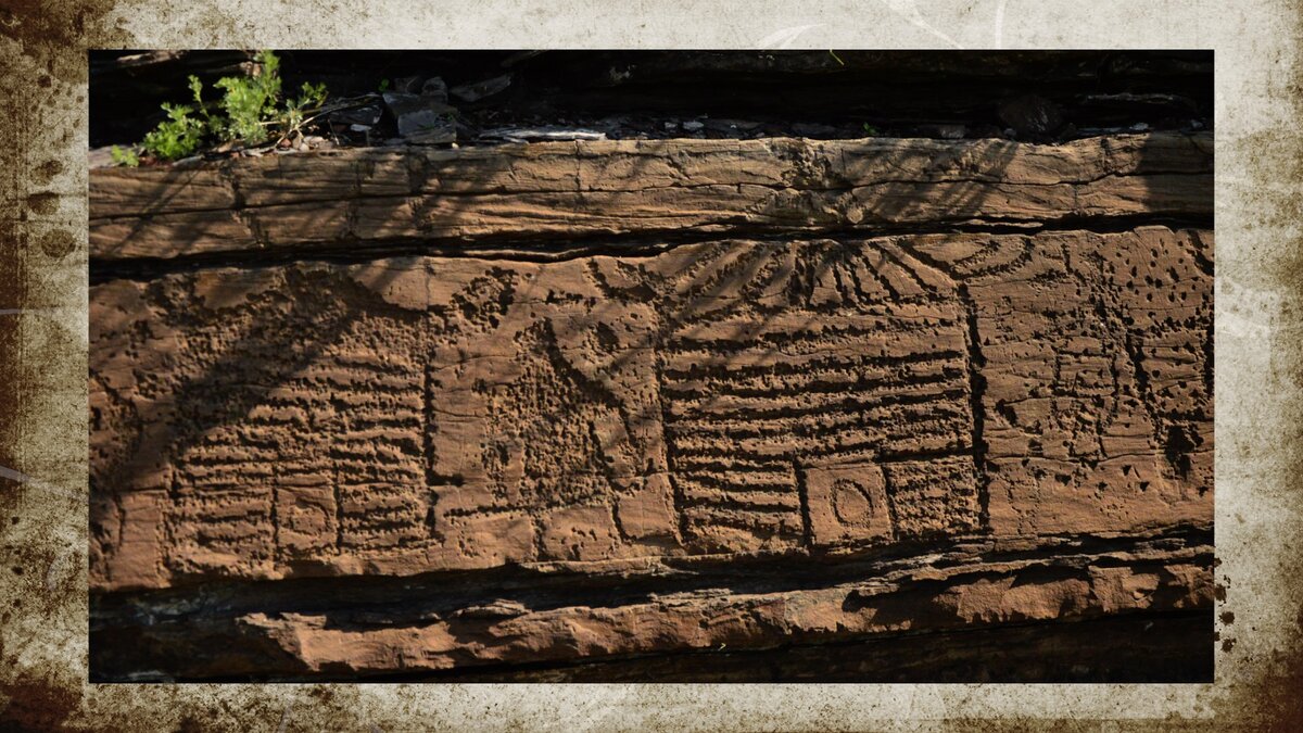Нарисованный на скале поселок тогарцев - это и рубленые бревенчатые избы и юрта кочевника, стоящая рядом. 
