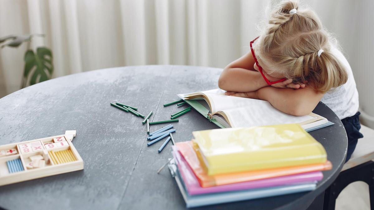    Девочка уснула за столом, читая книгу:pexels.com