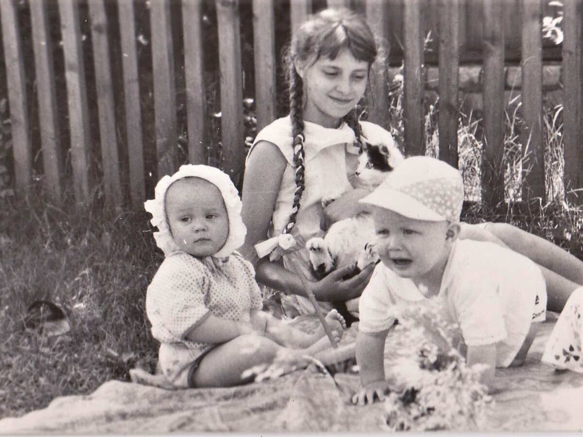 Малыши и школьница с котом на травке. Фото из архива автора