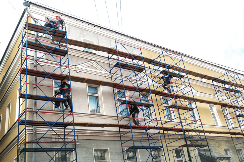 Ремонт здания со стротельных лесов, рабочими