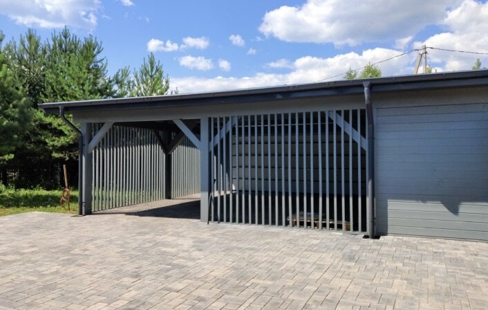 Фотография готового навеса с сайта компании Норд Хаус Киров — psk-nord.ru. Навес выкрашен в цвет фасада дома