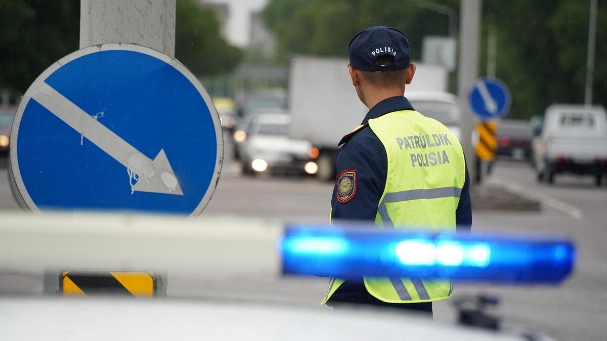    Полицейский стоит возле машины:NUR.KZ/Владимир Третьяков