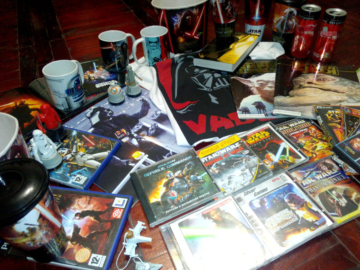 Фото из моей личной коллекции. Публикация фото преследует в информационные цели. На фото сувениры из моей ретро коллекции по Звездным войнам: Майка, банки из под газировки, кружки, картонные ведра из под попкорна, фигурки, коробки от игр на Плейстейшн 1, 2 издателя LucasArts, книга Звёздные Войны. Оригинальная трилогия, автор Джордж Лукас, издательство Азбука. Подробнее указано в статье.