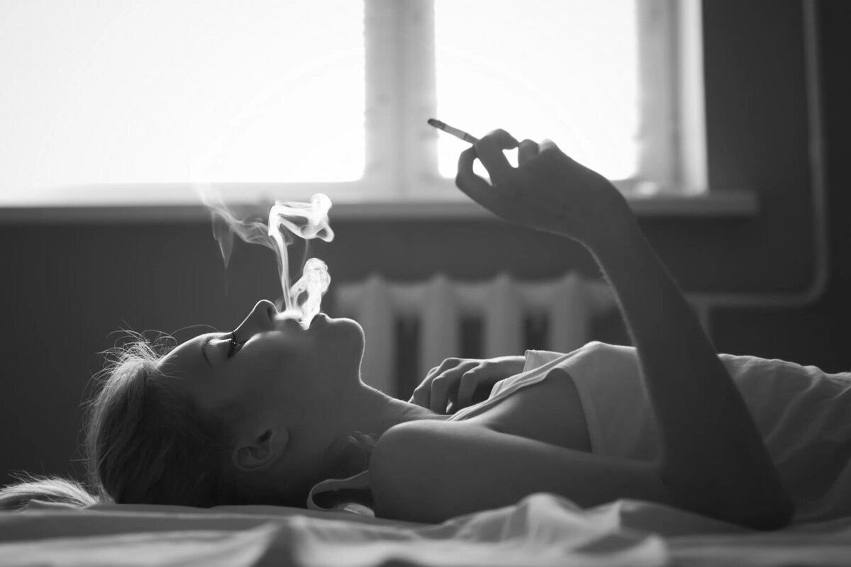 Девушка лежит с сигаретой