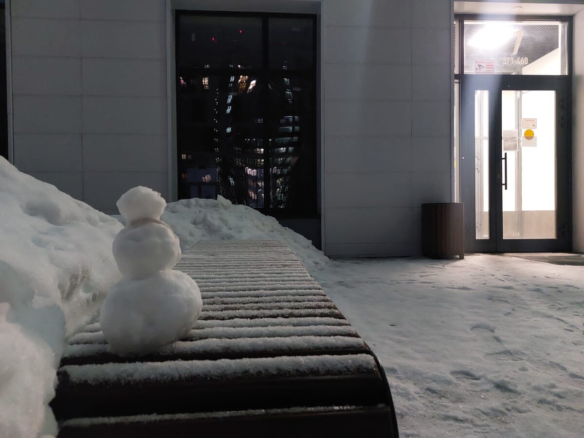 Снеговик-кроха в ожидании друзей на лавочке